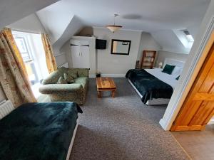 a bedroom with a bed and a couch and a chair at The Stables, Bron Y Graig, Corwen in Corwen