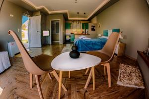 ein Wohnzimmer mit zwei Stühlen, einem Tisch und einem Bett in der Unterkunft Atrium Vinea Brintziki Winery in Iráklia