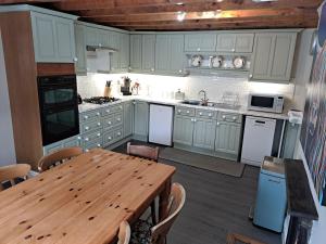 cocina con mesa de madera, mesa de madera y mesa de madera en The Stables, Bron Y Graig, Corwen, en Corwen