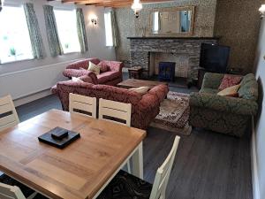 a living room with a table and chairs and a fireplace at The Stables, Bron Y Graig, Corwen in Corwen