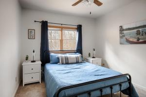 - une chambre avec un lit doté d'une couette bleue et d'une fenêtre dans l'établissement Huge Chalet Cabin w Hot Tub, Wraparound Deck, WiFi, à Great Cacapon