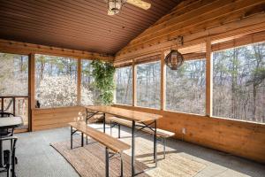 - une salle à manger avec une table et des bancs dans une cabine dans l'établissement Huge Chalet Cabin w Hot Tub, Wraparound Deck, WiFi, à Great Cacapon