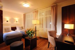 a hotel room with a bedroom with a bed and a desk at Armon Residence in Kraków