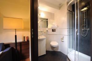 a bathroom with a shower and a toilet and a sink at Armon Residence in Kraków