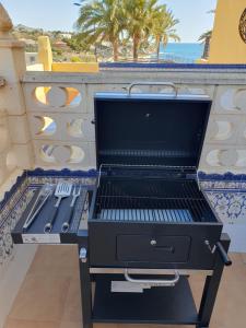 a grill on a balcony with a view of the ocean at Apartamento Alkabir Playa in El Campello