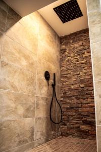 a bathroom with a shower with a stone wall at Honoré - Rooftop- Centre Vieux Port in Marseille