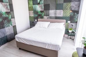 1 cama en un dormitorio con una pared verde y gris en Lilium Maris Hotel, en Bibione