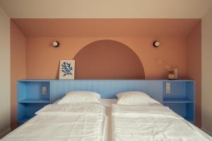 two beds in a room with a blue headboard at Morze Sasino in Sasino