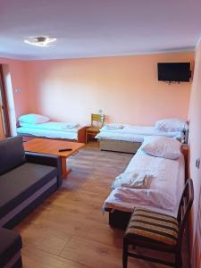 Habitación con 3 camas y sofá en Pokoje Mira, en Torzym