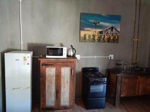 a kitchen with a refrigerator and a microwave on a counter at Perdestal in Oranjeville