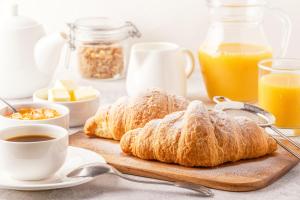 a table with croissants and a cup of coffee and orange juice at VOI Praia de Chaves Resort in Sal Rei