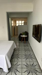 Zimmer mit einem Bett, einem Tisch und einem Sofa in der Unterkunft Apartamento Frente à Praia Santos in Santos