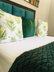 a bed with two pillows and a green head board at Skills Tree 58 Pty Ltd in Empangeni