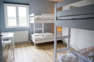 Zimmer mit 2 Etagenbetten, einem Tisch und einem Fenster in der Unterkunft Orsa Grönklitt in Orsa