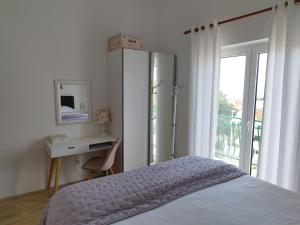 1 dormitorio con cama, escritorio y ventana en Apartments Proto, en Primošten