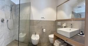 a bathroom with a sink and a toilet and a shower at Pension Moarhof in Feldthurns