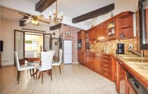una cucina con armadi in legno, tavolo e sedie di 3 Bedroom Stunning Home In Cabestany a Cabestany