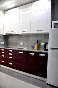 uma cozinha com armários brancos, um lavatório e um frigorífico em 150 metres to Ploscha Rynok em Lviv