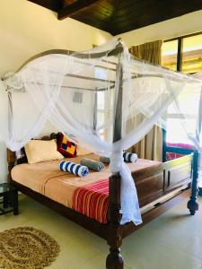 a bed with a canopy in a room at Blue Ocean Resort in Netolpitiya