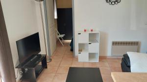 a living room with a flat screen tv and a couch at Villa Sénégas in La Roque-sur-Cèze
