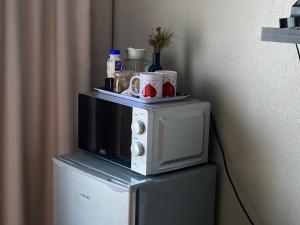 a microwave sitting on top of a refrigerator at Christa's Place 899 in Pretoria