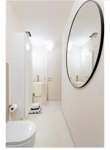 uma casa de banho com um espelho redondo na parede em Luxury Tower House in heart of Pisa Standard em Pisa