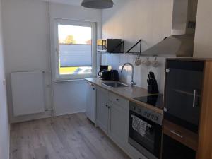 a kitchen with a sink and a stove and a window at Lotus 4 in Cuxhaven