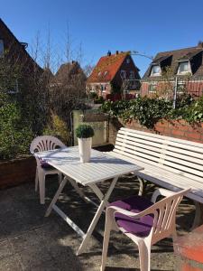 a picnic table and two chairs on a patio at Lotus 4 in Cuxhaven