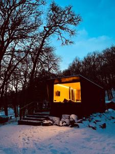 a small house with a large window in the snow at The Roost in Aviemore