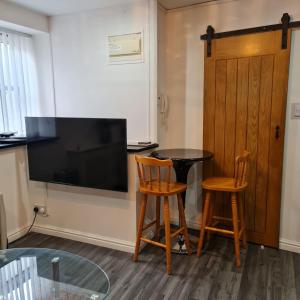 a room with a table and two chairs and a television at Town Centre Maisonette in Ulverston