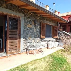 une terrasse avec une table et des chaises devant une maison dans l'établissement La Circumetnea Home, à Catane