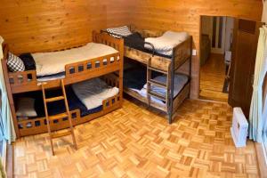 a room with three bunk beds in a cabin at 『一軒丸々貸切』徒歩5分圏内カフェ 自然を満喫 Modern Ski Chalet +WiFi & 5min walk to cafes. in Nagano