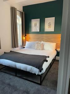1 cama grande en un dormitorio con una pared verde en Cleethorpes - New 2 Bedroom house close to beach, en Cleethorpes