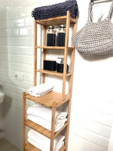 estante de madera en el baño con toallas en Apartamento Los Naranjos de Santa Justa en Sevilla