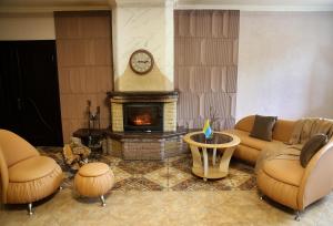 a living room with a couch and a fireplace at Den House in Ludvikuvka