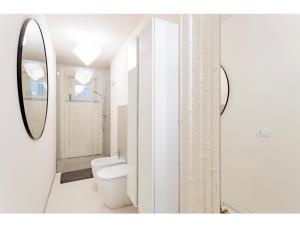 uma casa de banho branca com um WC e um espelho. em Luxury Tower House in heart of Pisa Standard em Pisa
