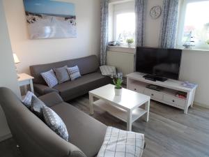 a living room with a couch and a tv at Scheitz 2 in Dahme