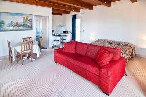 ein Wohnzimmer mit einem roten Sofa und einem Tisch in der Unterkunft SARI CASA VACANZE in Nardò