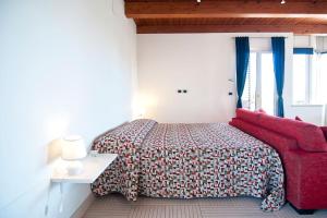 ein Schlafzimmer mit einem Bett und einem roten Sofa in der Unterkunft SARI CASA VACANZE in Nardò