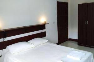 1 dormitorio con cama blanca y cabecero de madera en Chochotel Panglao Monaco suite 58sqm en Panglao City