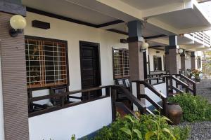 un porche delantero de una casa con barandilla de madera en Chochotel Panglao Monaco suite 58sqm en Panglao City