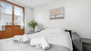 Un dormitorio con una gran cama blanca y una ventana en HOMEY ARBUSTRO - Petit Studio - Proche frontière et Tram - Wifi en Gaillard