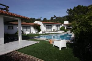 a backyard with a swimming pool and a house at Sítio Do Louro Villa in São Martinho do Porto