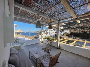 un patio con tavolo, sedie e vista sull'oceano di GiSt a Livadi Astypalaias