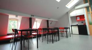 a group of tables and chairs in a room at 25 Hours Hostel in Vilnius