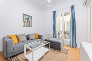 uma sala de estar com um sofá cinzento e uma mesa em Montaber Apartments - La Paz Market em Madrid