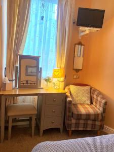 a bedroom with a desk and a chair and a mirror at Cobbleview Rooms in Whitby