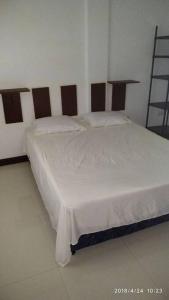 sypialnia z białym łóżkiem z drewnianym zagłówkiem w obiekcie Chochotel Panglao Martina Studio 26 sqm good for 2/3 w Panglao City