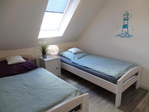 two beds in a room with a lighthouse on the wall at Scheitz 2 in Dahme