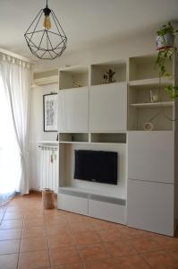 a living room with a tv and white shelves at Il Sestante Santa Marinella in Santa Marinella